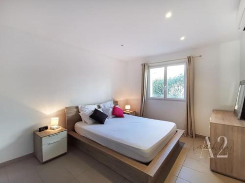 une chambre avec un lit avec des draps blancs et une fenêtre dans l'établissement Appartement 4 Pers - Cala Rossa - Piscine, à Lecci