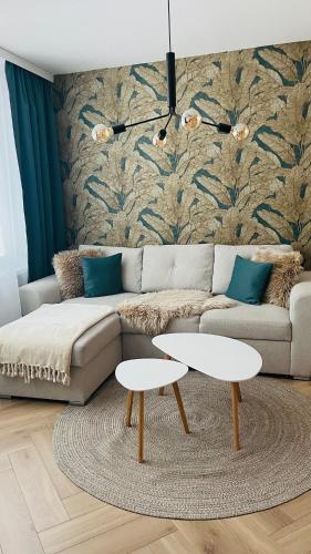 een woonkamer met een bank en twee tafels bij APARTMÁN STYLE Brezno in Brezno