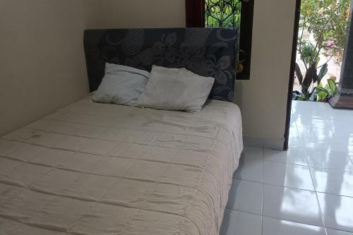 庫塔的住宿－SPOT ON 93724 Songgong Homestay，一张床上有两个枕头的房间