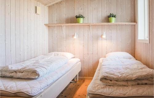 two beds in a room with plants on the wall at Stunning Home In Rudkbing With Sauna in Spodsbjerg