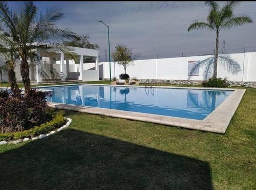 una piscina en un patio con palmeras en Excelente lugar para descansar, en Emiliano Zapata
