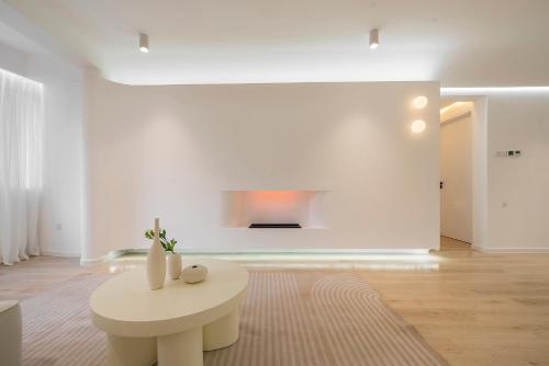 a white living room with a table and a fireplace at Shanghai Yi Du B&B - Near near Jiaotong University and Hongqiao Station in Shanghai