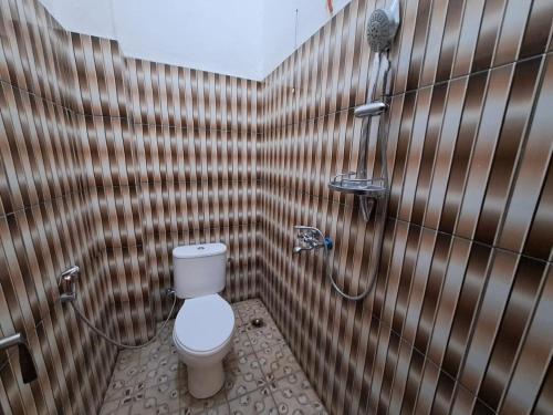 a bathroom with a toilet and a shower at OYO 93714 Guest House Gembul Syariah in Jambi