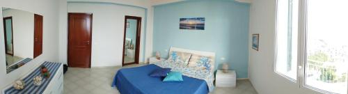 a blue room with a bed with a blue table at Le finestre sul mare in Santa Flavia