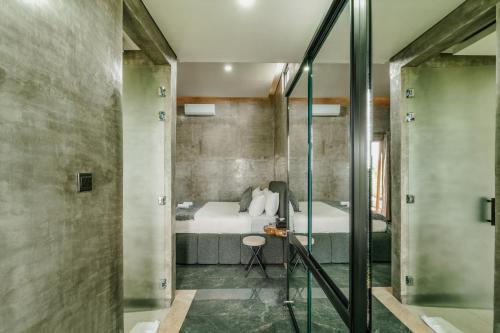 um quarto com uma cama e uma casa de banho com um chuveiro em Casa Jenah em Darmasaba