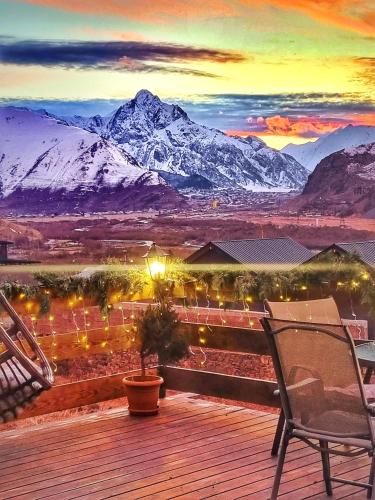 a deck with a view of a snow covered mountain at Sunshine Kazbegi in Stepantsminda