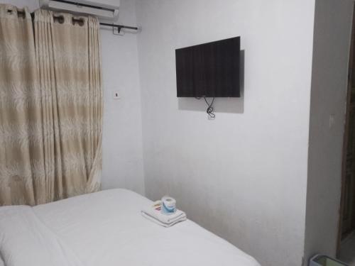 sypialnia z łóżkiem i telewizorem z płaskim ekranem w obiekcie Mid Way Best Hotel w mieście Lagos