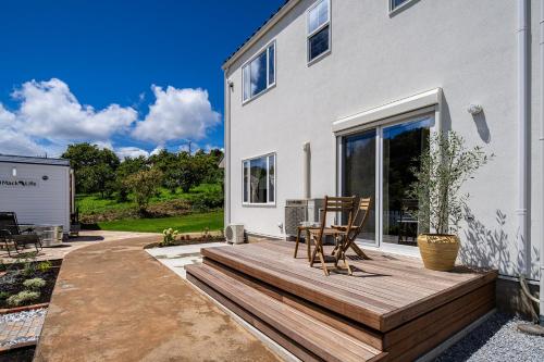 una terrazza in legno con due sedie su una casa di 白キツネのおうち a Nagatsutachō