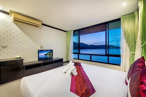 um quarto com uma cama grande e uma janela grande em Racha Kiri Resort & Spa, Khanom em Khanom