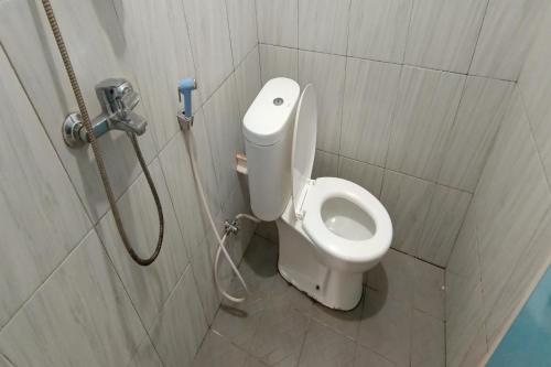 uma casa de banho com um WC branco numa cabina em OYO 93752 Aglo Homestay em Rantau