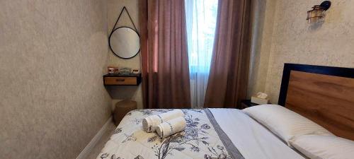 een slaapkamer met een bed, een spiegel en een raam bij Apartment Rustaveli 118 in Koetaisi