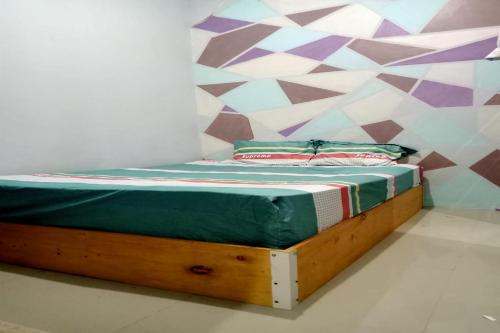 1 cama con marco de madera en una habitación en OYO 93737 Bale Oyan Homestay en Kuta Lombok