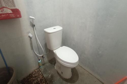 a bathroom with a white toilet in a stall at OYO 93737 Bale Oyan Homestay in Kuta Lombok
