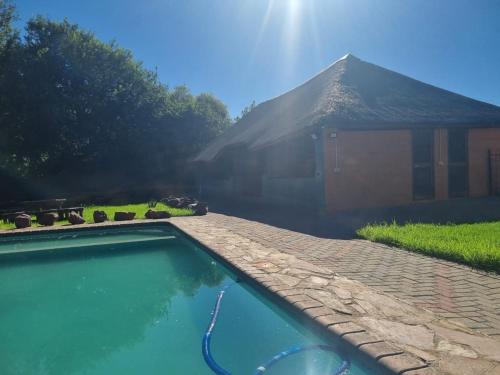 a swimming pool in front of a house at De Prince Lodge in Vereeniging