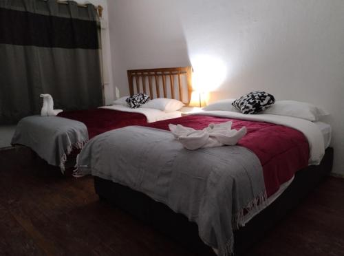 two beds in a hotel room with towels on them at La Cortesana in Mexico City