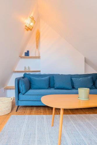 un canapé bleu dans un salon avec une table dans l'établissement Bright one bedroom next to Wazemmes market, à Lille