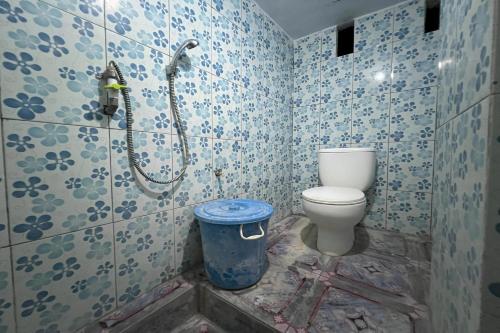a bathroom with a toilet and a shower in it at OYO 93753 Rafira Losmen in Rantau