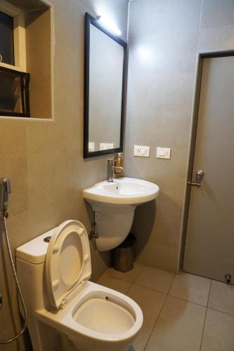 a bathroom with a toilet and a sink at TREETOP INN in Chennai