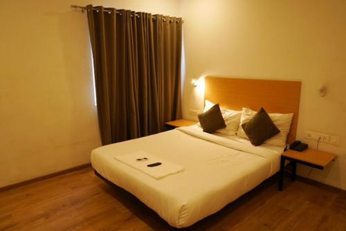 a bedroom with a large white bed in a room at TREETOP INN in Chennai