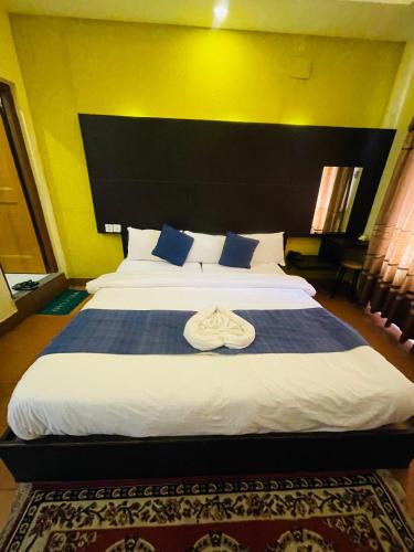 a bedroom with a large bed with a large headboard at Hotel Middle Town in Pokhara
