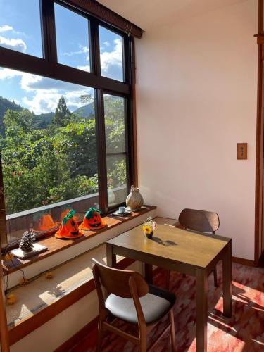 a room with a table and chairs and a large window at Yunominesou in Hongu