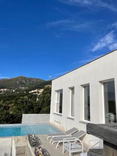 une villa avec piscine et chaises longues dans l'établissement Villa Phi, à Oletta