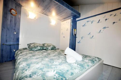 a bedroom with a bed with birds on the wall at Petit coin de paradis à Port-Leucate in Port Leucate