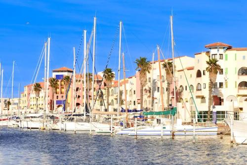 a group of boats docked in a marina with buildings at Petit coin de paradis à Port-Leucate in Port Leucate
