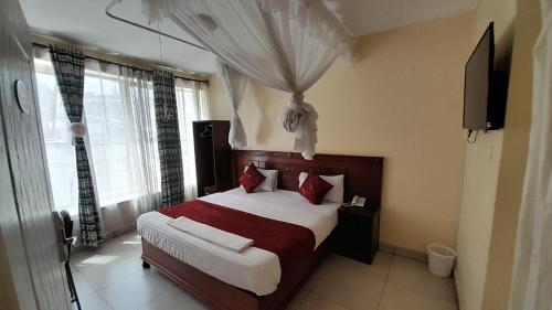 sypialnia z dużym łóżkiem z czerwonymi poduszkami w obiekcie Epitome Times Hotel w mieście Nairobi
