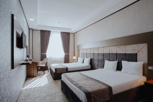 a hotel room with two beds and a window at Volga Hotel Baku in Baku