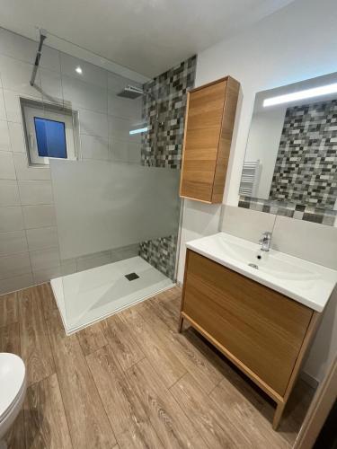 une salle de bain avec un lavabo et des toilettes dans l'établissement La Maison Bleue - 300m de la mer, à Pleubian