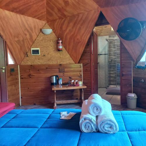 a room with a bed with towels on it at Puelo EnDomos in Lago Puelo
