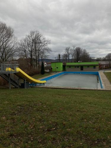 a swimming pool with a slide and a playground at Autokemp s koupalištěm in Nový Jičín