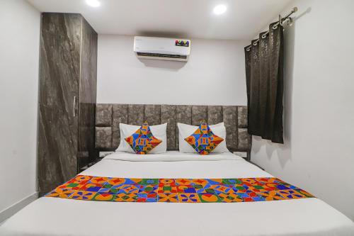 1 dormitorio con 1 cama con una manta colorida en FabExpress Super 8 Residency, en Nueva Delhi