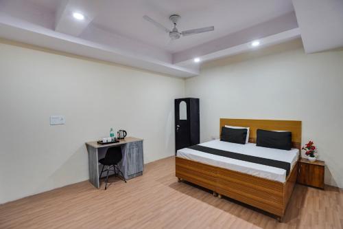 a bedroom with a bed and a desk in it at OYO Lotus Inn in New Delhi