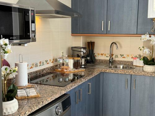 una cucina con mobili blu e un lavandino di Ronda Centro - Glamour a Ronda