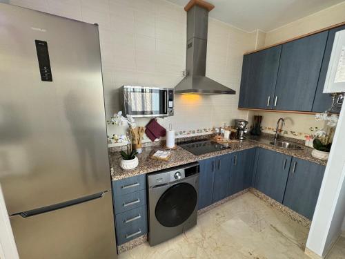 una cucina con armadi blu e frigorifero in acciaio inossidabile di Ronda Centro - Glamour a Ronda