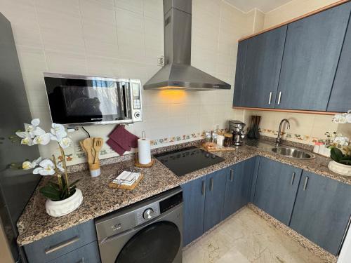 una cucina con armadi blu e lavatrice di Ronda Centro - Glamour a Ronda