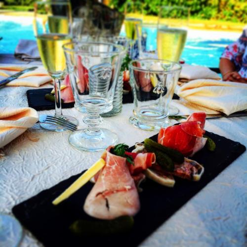 a table with plates of food and glasses of wine at Logis Hotel La Grange Du Relais in Colombey-les-deux-Églises