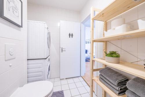a small bathroom with a refrigerator and a toilet at Nice Apartment in Blankenfelde-Mahlow in Blankenfelde