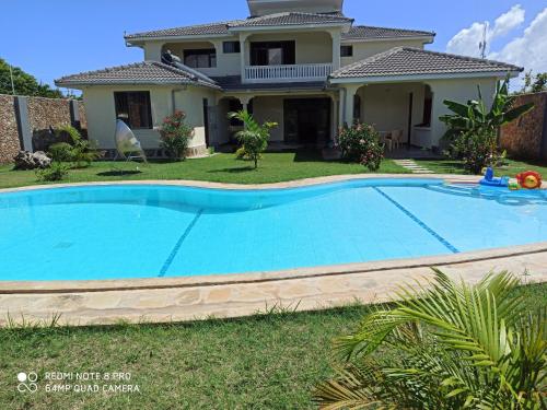 a swimming pool in front of a house at Lisa Mari in Mombasa