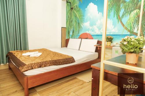 1 dormitorio con 1 cama con un mural tropical en Hello Hotel en Ho Chi Minh