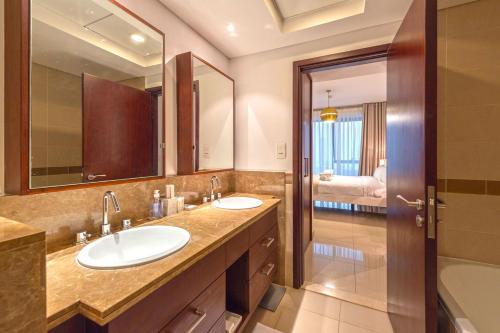 a bathroom with two sinks and a large mirror at Spectacular Burj Khalifa & Fountain View 2 Bedroom Apartment, 29 Boulevard Tower in Dubai