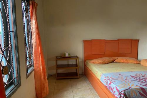 um pequeno quarto com uma cama e uma janela em OYO 93774 Khaira Kos Dan Penginapan em Rantau