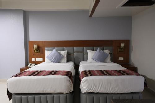 two beds sitting next to each other in a room at Eastin Hotels- Madhapur in Hyderabad