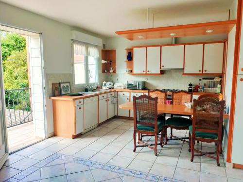 una cocina con mesa y sillas de madera en Villa Paris et parc d'expostions stade de France, en Aulnay-sous-Bois