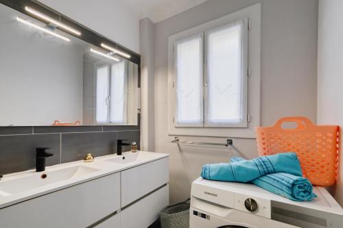 une salle de bain avec un lavabo et un miroir dans l'établissement Le Floreal - Vue mer, proche plage, parking privé, à Bandol