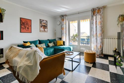 un salon avec un canapé bleu et une table dans l'établissement Le Floreal - Vue mer, proche plage, parking privé, à Bandol