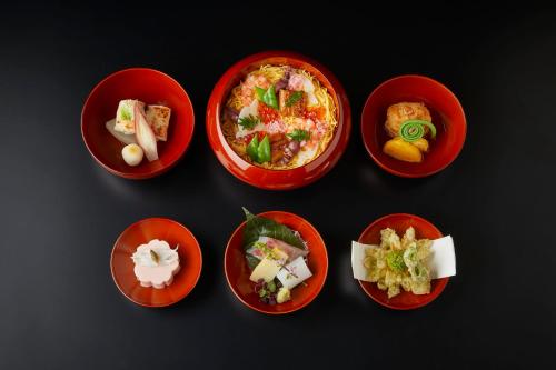 a group of four red bowls filled with food at The Ritz-Carlton, Tokyo in Tokyo