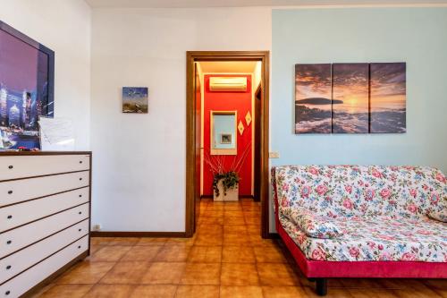 a bedroom with a couch and a dresser and a red door at Casa Vacanze Francesca in Bussolengo